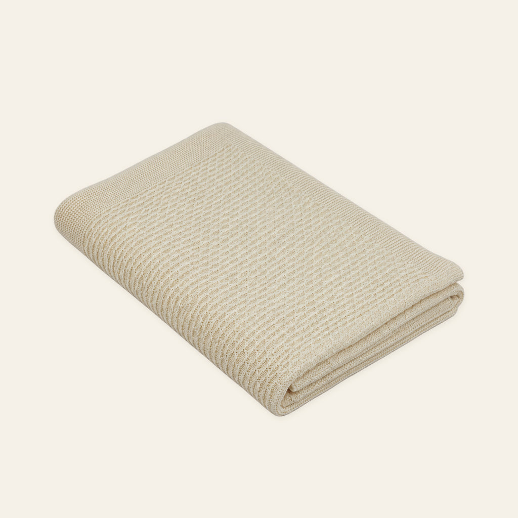 Pislak Luna wool children's blanket in cream, neatly folded in a studio view showing its fine textured knit.
