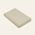 Pislak Luna wool children's blanket in cream, neatly folded in a studio view showing its fine textured knit.