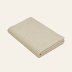 Pislak Luna wool children's blanket in cream, neatly folded in a studio view showing its fine textured knit.