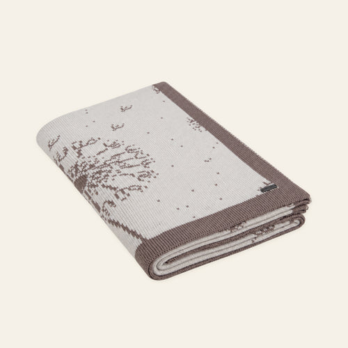 Pislak Dalia merino-blend blanket in sand and cream, neatly folded in a studio view showing its dandelion motifs.