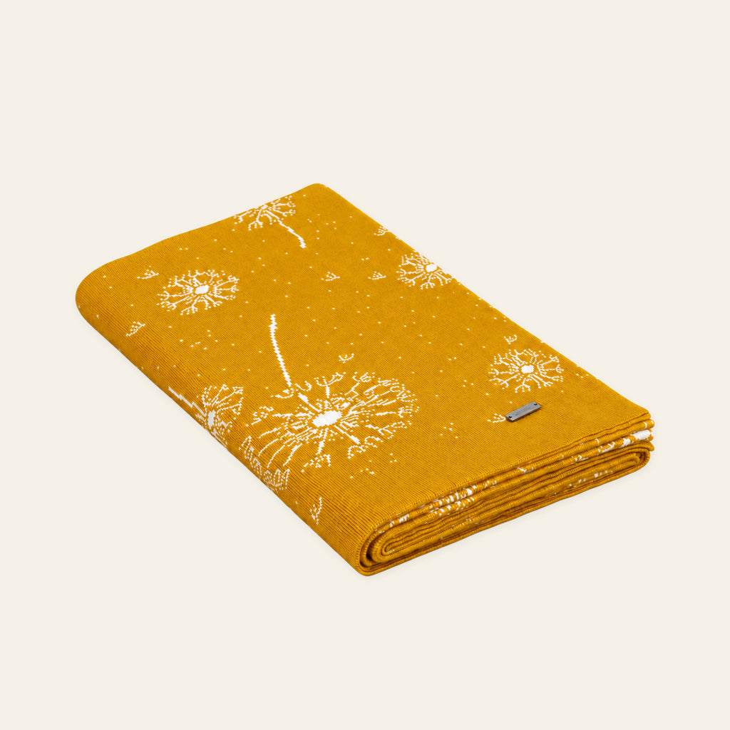 Pislak Lučka Kids' Knitted Blanket in curry, folded with dandelion motifs.