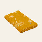 Pislak Lučka Kids' Knitted Blanket in curry, folded with dandelion motifs.