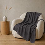 Pleta knitted blanket – Anthracite, alternate studio view