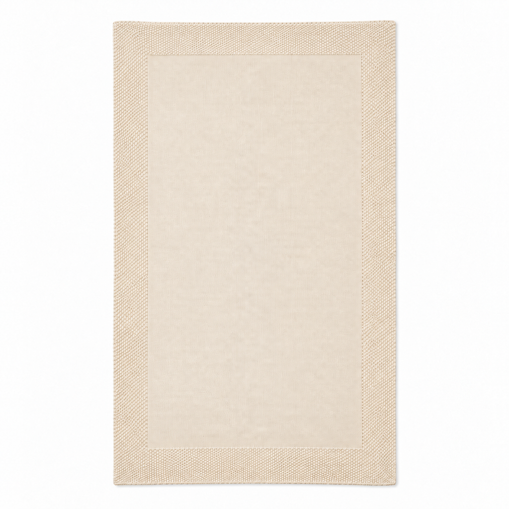 Tinka throw in cream, shown fully unfolded with a fine knitted centre and a broad textured border.