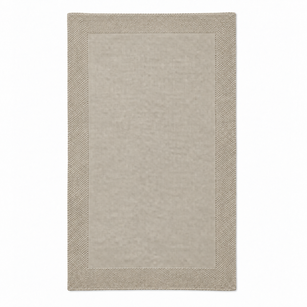Tinka throw in light beige, shown fully unfolded with a fine knitted centre and a broad textured border.
