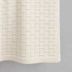 Buba baby blanket in cream, detail of the fine rectangular knit pattern and borders.