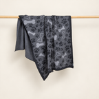 Čarli blanket in grey, hanging folded to show paw and bone motifs and its reverse side.