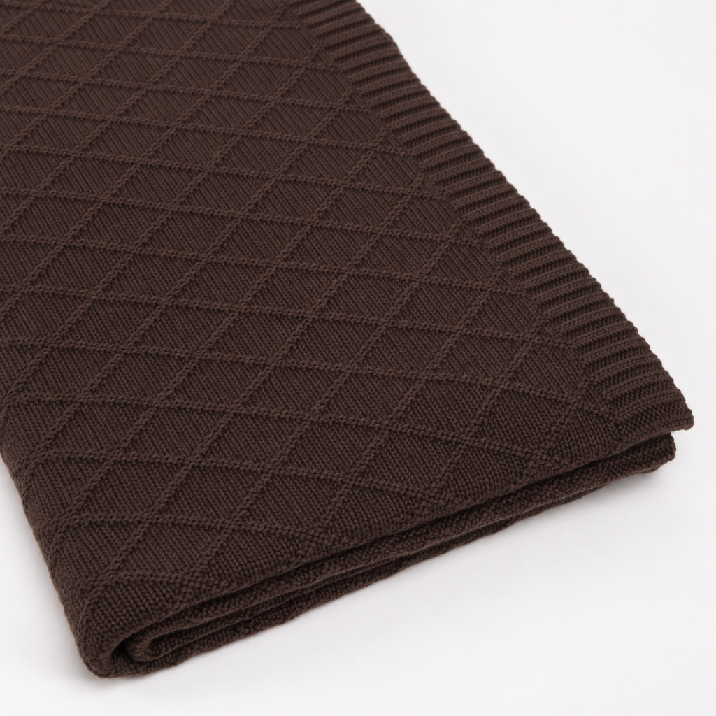 KARO throw in dark brown, detail of the fine diamond knit, ribbed border and folded layers.