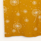 Lučka blanket in curry yellow, detail of the dandelion seed-head pattern.