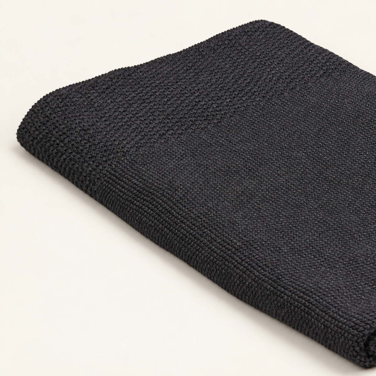 Tinka throw in anthracite, detail of the fine knit surface and broader textured border.
