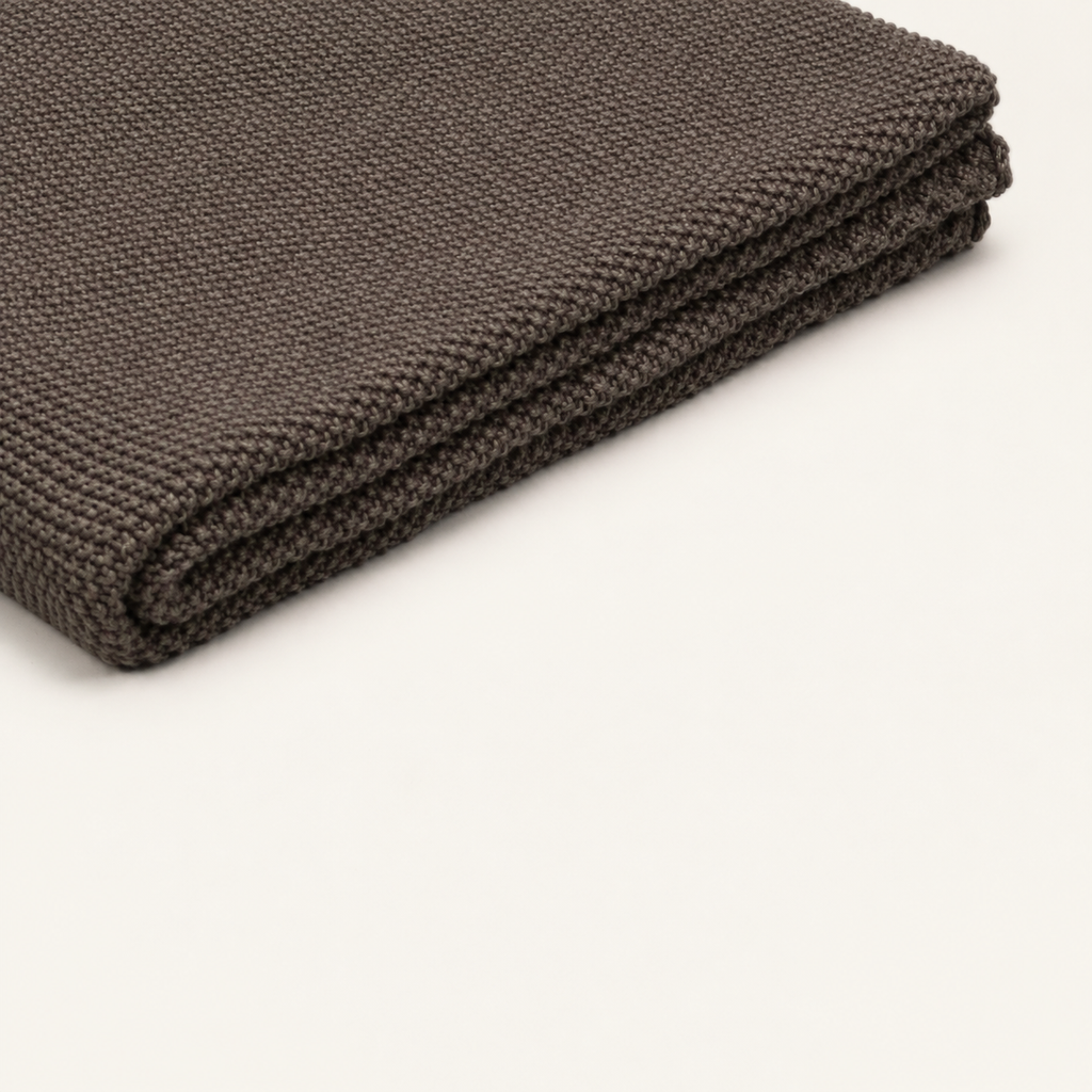 Tinka throw in taupe, close view of the thin folded layers and knitted edge.
