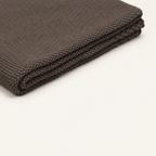 Tinka throw in taupe, close view of the thin folded layers and knitted edge.