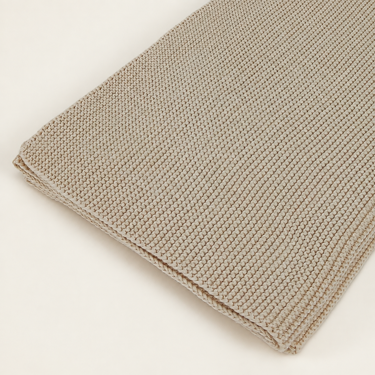 Zarja blanket in cream, detail of fine garter-knit rows and the thin finished edge.